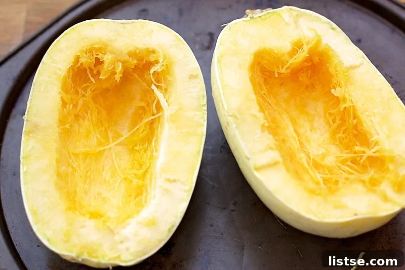 Cooked spaghetti squash strands neatly collected in a large mixing bowl, ready for the cheese sauce.