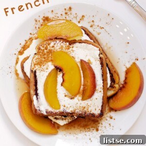 A beautifully plated stack of Bourbon Peach French Toast, drizzled with syrup and topped with mascarpone, ready to be served