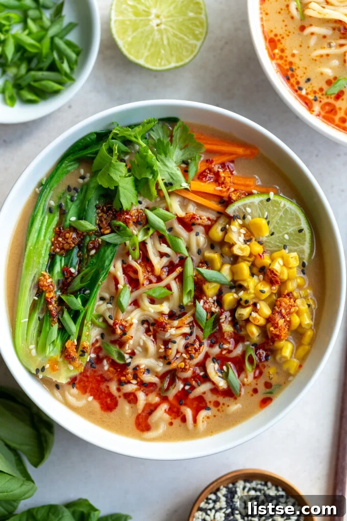 A beautifully arranged bowl of Peanut Miso Ramen, garnished with fresh herbs and chili oil, showcasing its rich, creamy broth and perfectly cooked noodles.