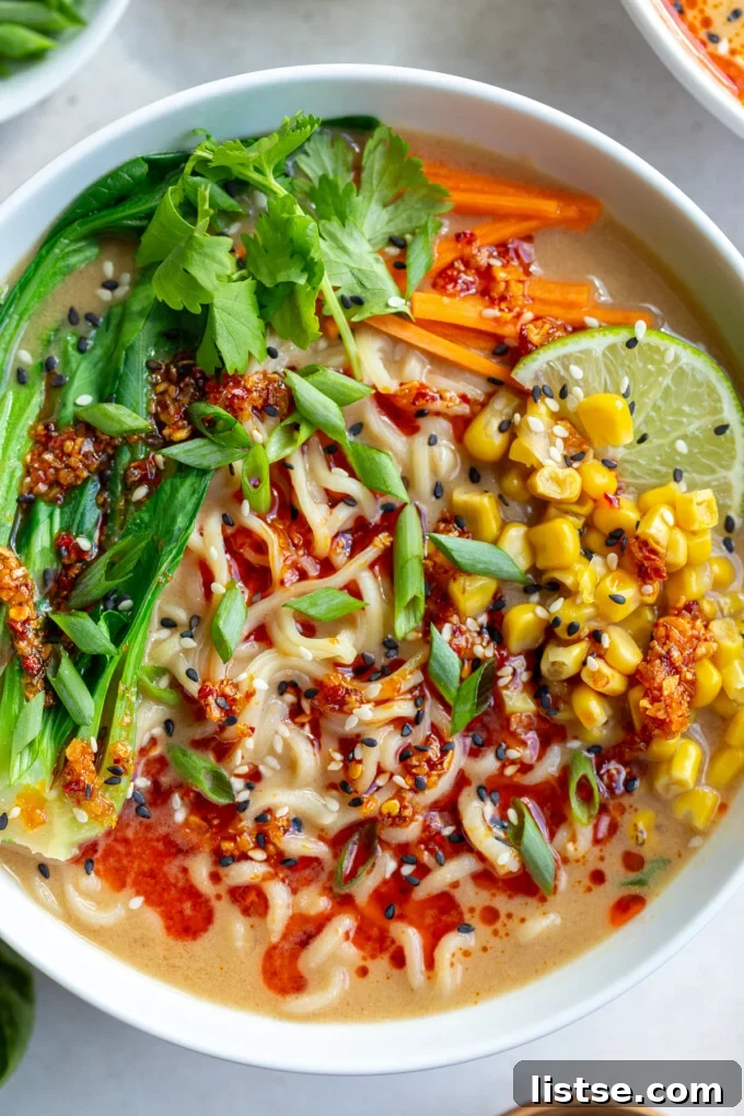 A vibrant bowl of Peanut Miso Ramen, garnished with fresh cilantro, a drizzle of chili oil, and toasted sesame seeds, ready to be enjoyed.