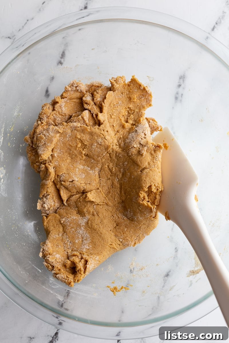 Stirring together pumpkin biscuit batter in a bowl.