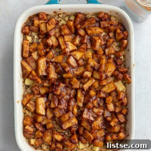 baked oatmeal topped with cinnamon apple chunks in a small teal baking dish