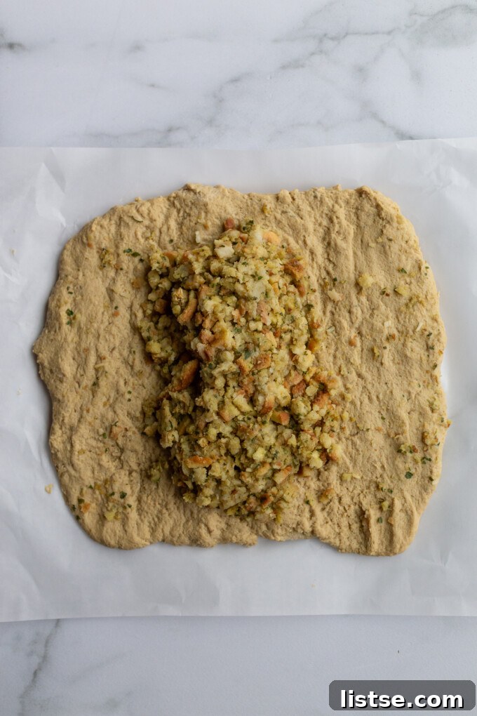Stuffed Vegan Holiday Roast 5 The initial step of making a seitan roast, showing the prepared seitan dough rolled out into a neat rectangle with a generous portion of stuffing placed centrally.