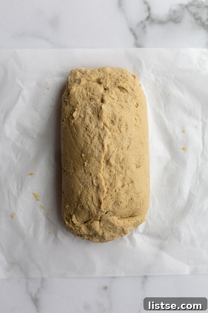 Stuffed Vegan Holiday Roast 7 A sealed seitan loaf, with the stuffing completely enclosed, resting on parchment paper, showcasing the successful formation of the roast.