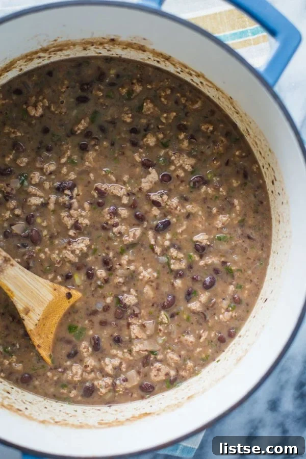 Spicy Turkey Black Bean Stew 5 Immersion blender being used to puree Spicy Black Bean Stew in a pot