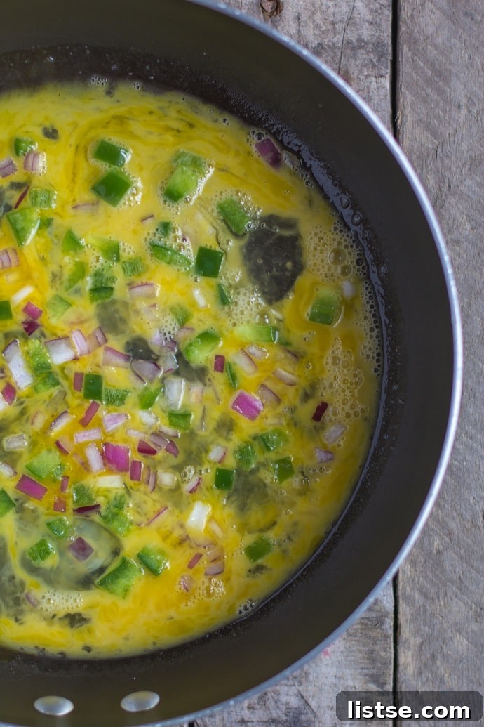 Egg scramble cooking in a pan with various vegetables