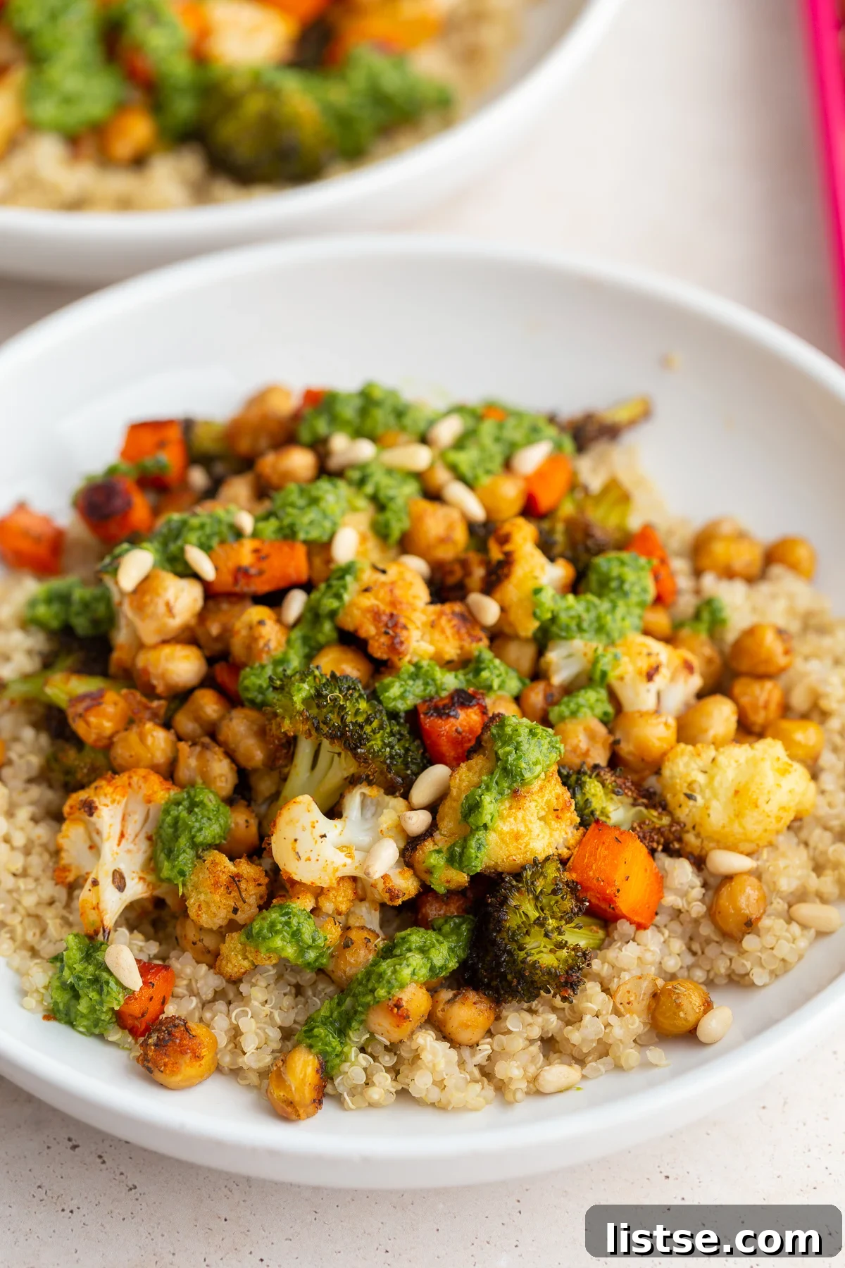 A close-up of beautifully roasted vegetables generously coated in bright green chimichurri sauce, ready to be served