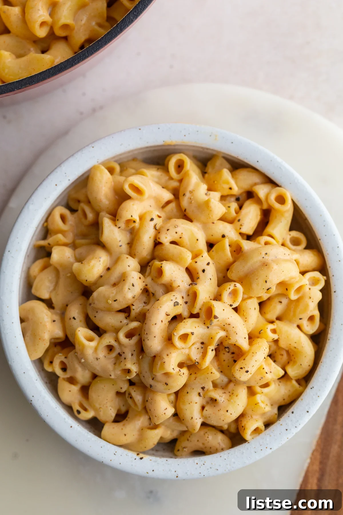 Creamy Vegan Tofu Macaroni and Cheese 2 A close-up shot of creamy Tofu Mac and Cheese in a white bowl, garnished with fresh parsley.