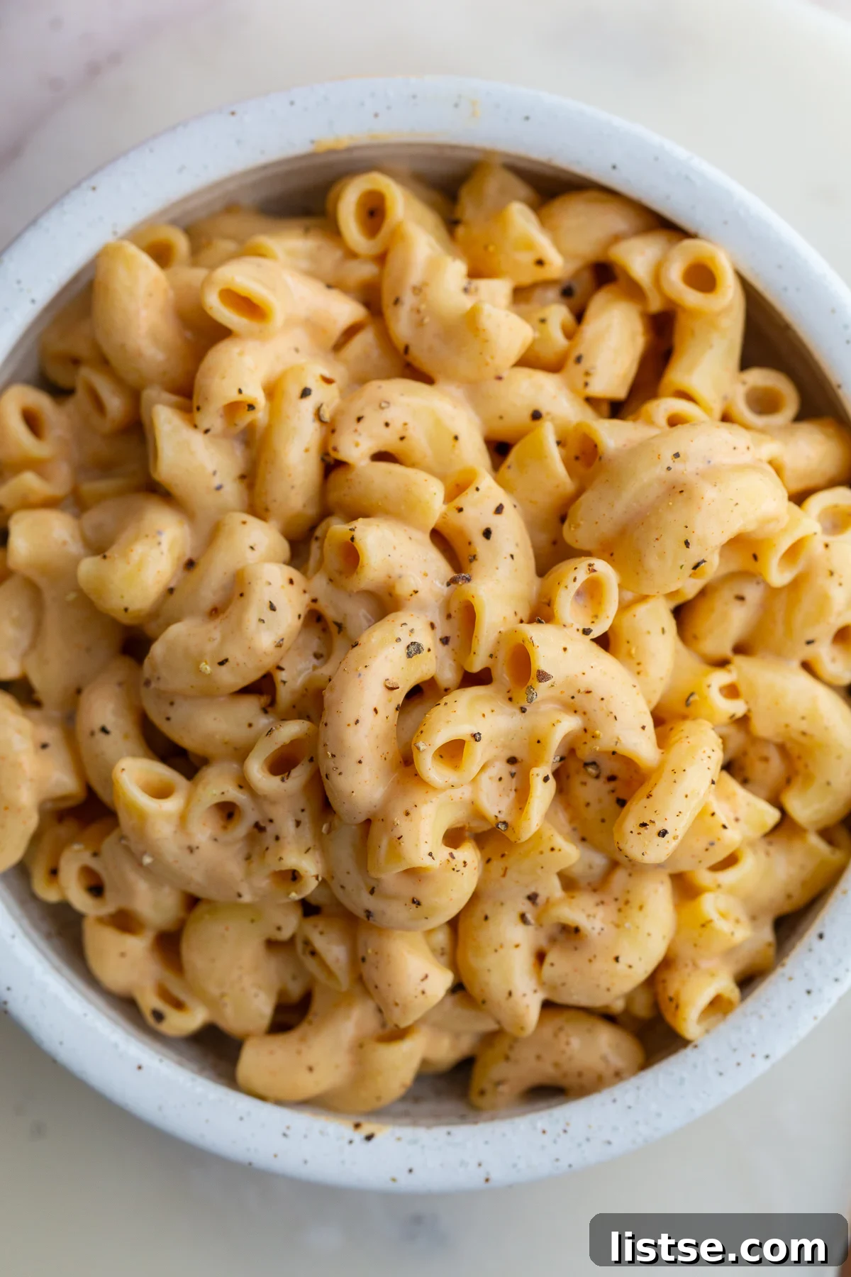 Creamy Vegan Tofu Macaroni and Cheese 6 Close-up of a serving of Tofu Mac and Cheese in a white bowl, showing its thick and creamy texture.