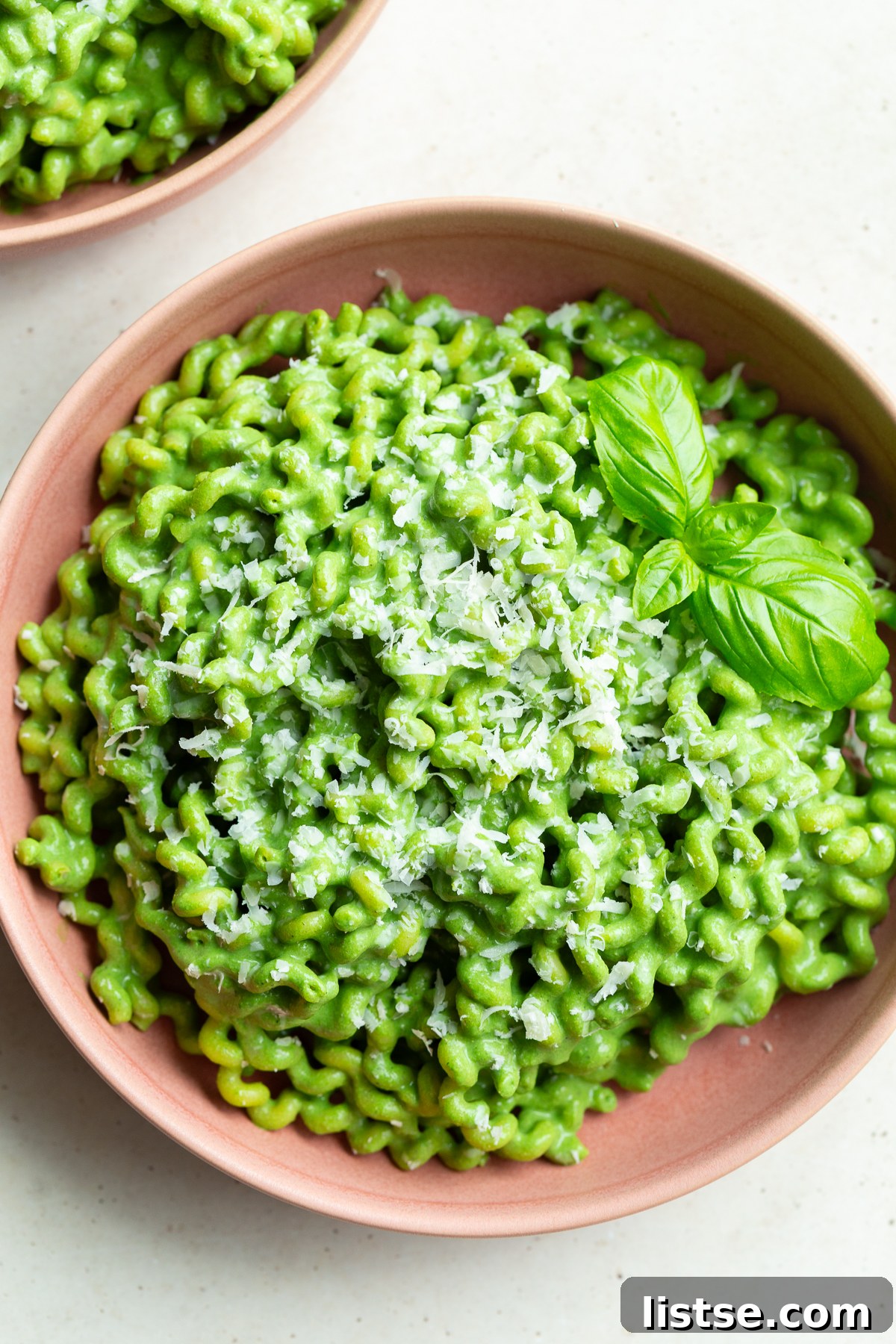 Emerald Goddess Pasta Delight 4 Close-up of vibrant Green Goddess Pasta, featuring short pasta coated in a rich, creamy green sauce, garnished with fresh basil leaves, suggesting a delectable and healthy meal.