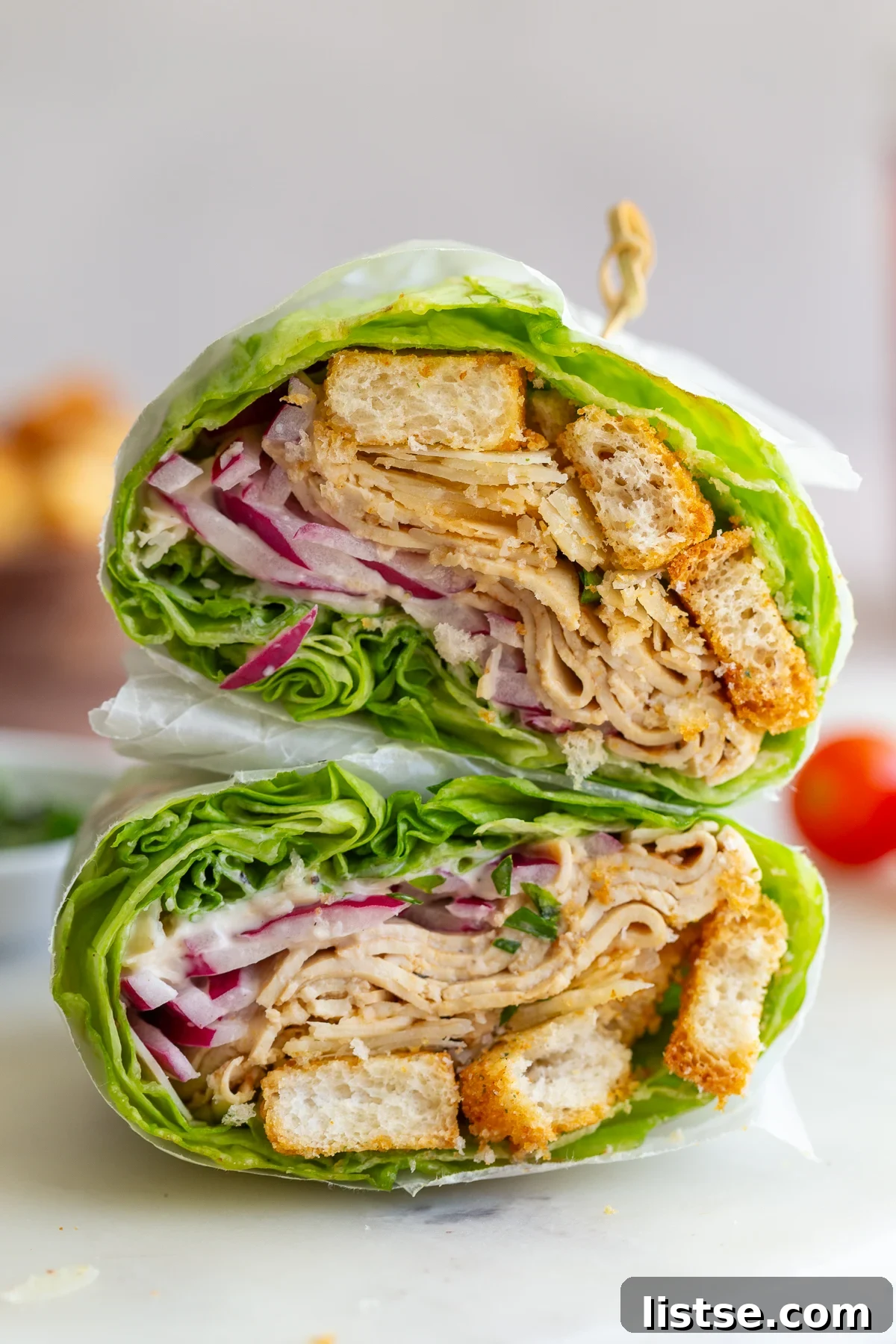 Close-up view of Caesar Tofu Lettuce Wraps, cut in half to reveal their vibrant and tempting interior layers.