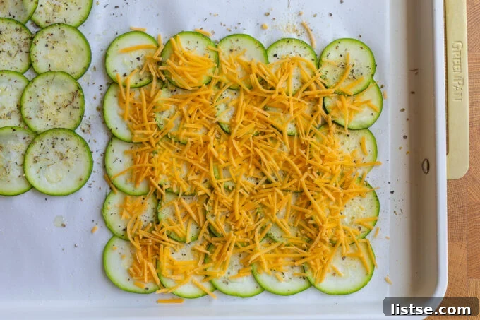 Skinny Zucchini Roll-Ups 5 Zucchini slices topped with seasoning and a generous layer of shredded cheese.