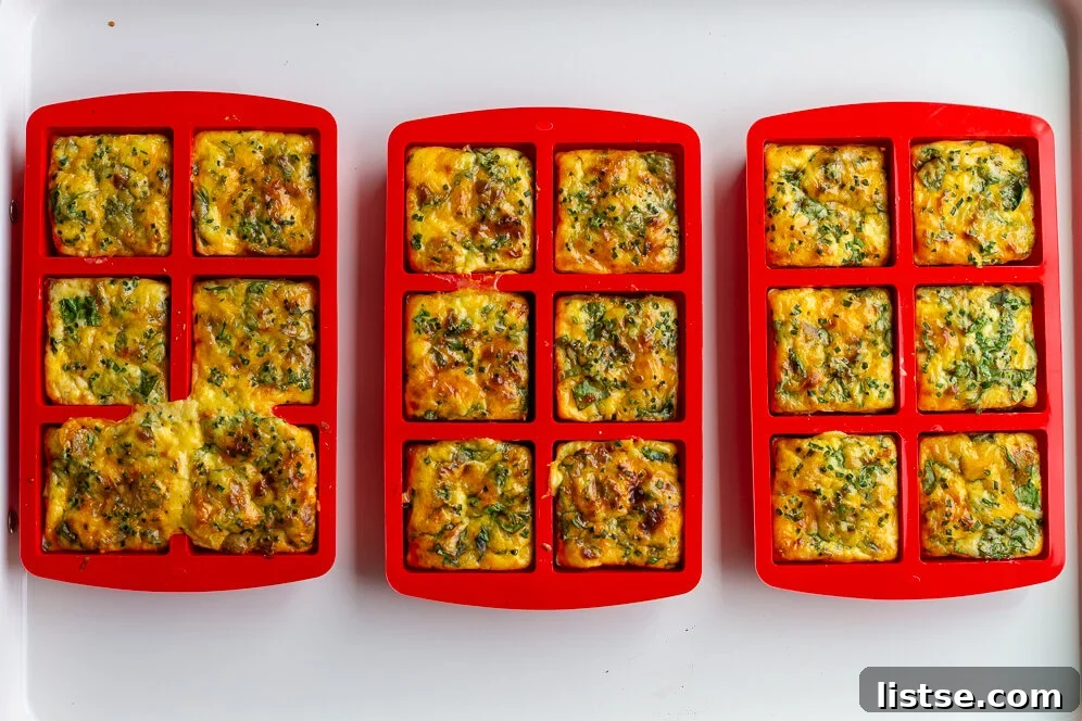Baked potato chive egg bites in bright red silicone molds, golden and ready to serve.
