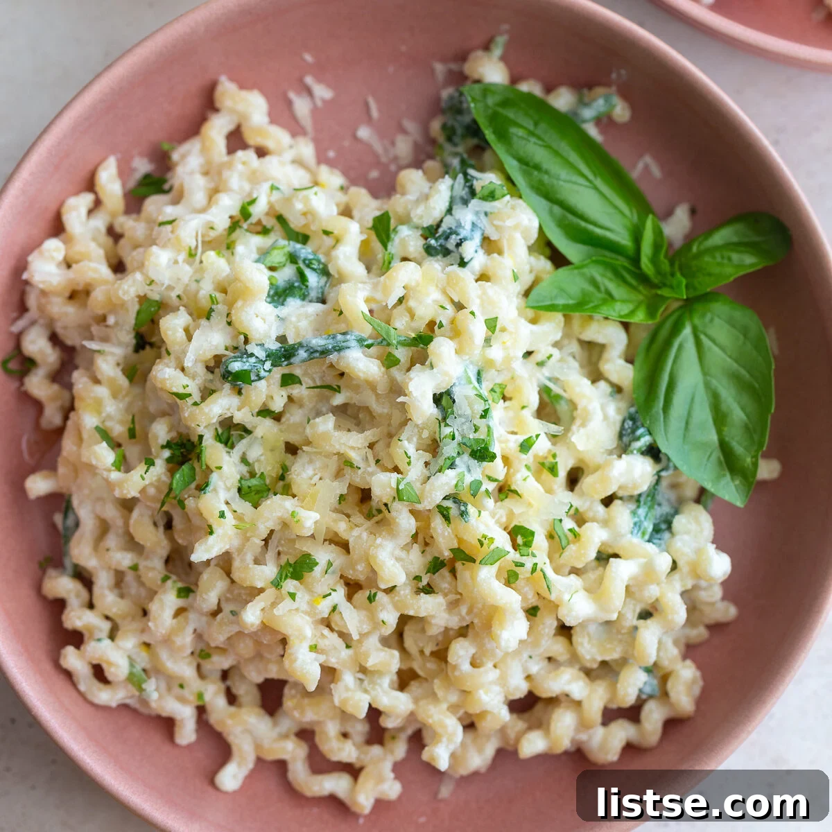A bowl of creamy ricotta pasta topped with fresh herbs and parmesan cheese