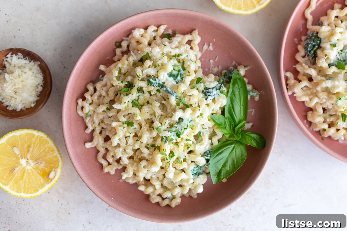 A bowl of creamy ricotta pasta topped with fresh herbs and parmesan cheese