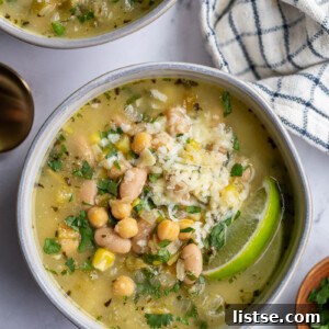 Weekly Meal Plan 23 5 Warm white chickpea chili topped with shredded cheese, fresh avocado slices, and a vibrant lime wedge.