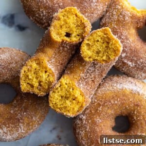 Weekly Meal Plan 23 8 Delicious cinnamon sugar baked pumpkin donuts arranged on a tray, with one donut cut in half to show its soft, spiced interior.