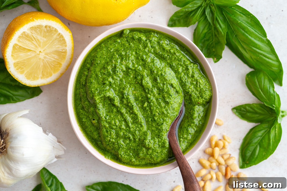 Crafting Perfect Homemade Basil Pesto 2 A bowl of fresh homemade pesto with a wooden spoon, garnished with lemons and basil leaves.