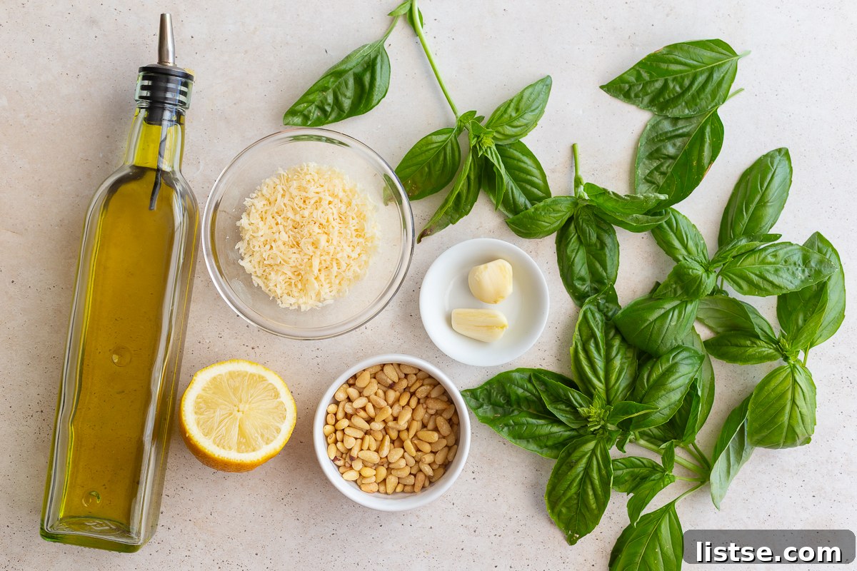 Crafting Perfect Homemade Basil Pesto 4 Ingredients laid out for making homemade pesto: olive oil, Parmesan, toasted pine nuts, fresh basil, lemon, and garlic.