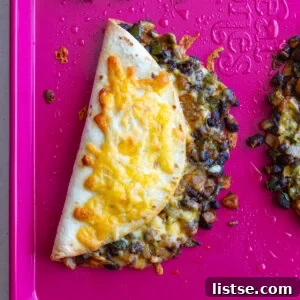 Crispy black bean tacos filled with savory seasoned beans and fresh toppings, ready to enjoy as a quick sheet pan meal.