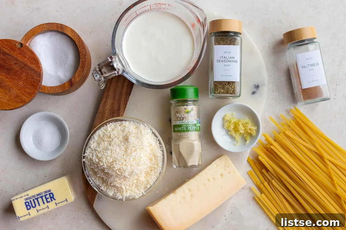 Luscious Homemade Alfredo in Minutes 4 Key ingredients laid out on a wooden surface, including butter, garlic, heavy cream, and Parmesan cheese, ready for making homemade alfredo sauce.