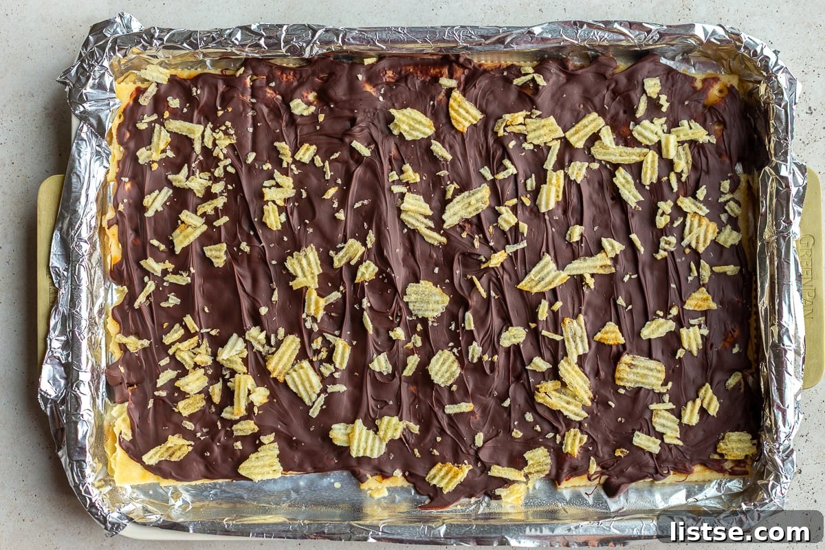 christmas crack candy on a baking tray and topped with crushed potato chips
