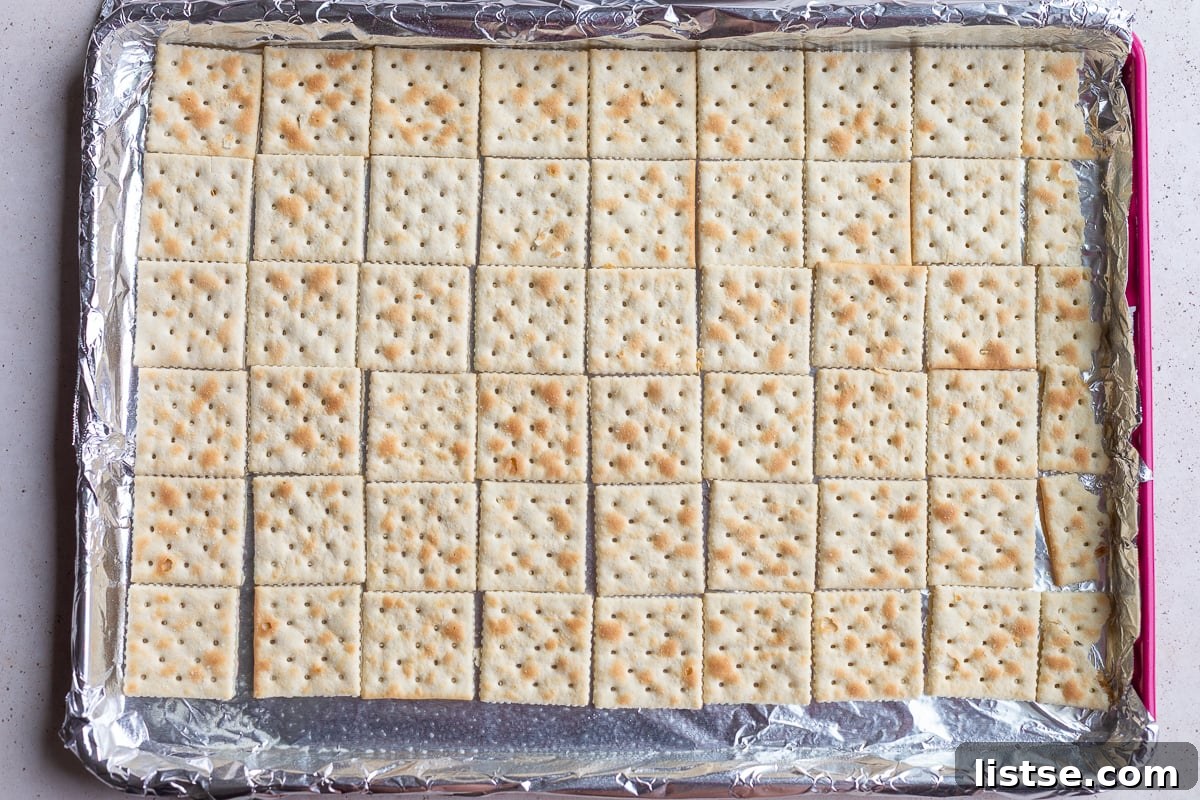saltine crackers lined up on a baking tray to make christmas crack