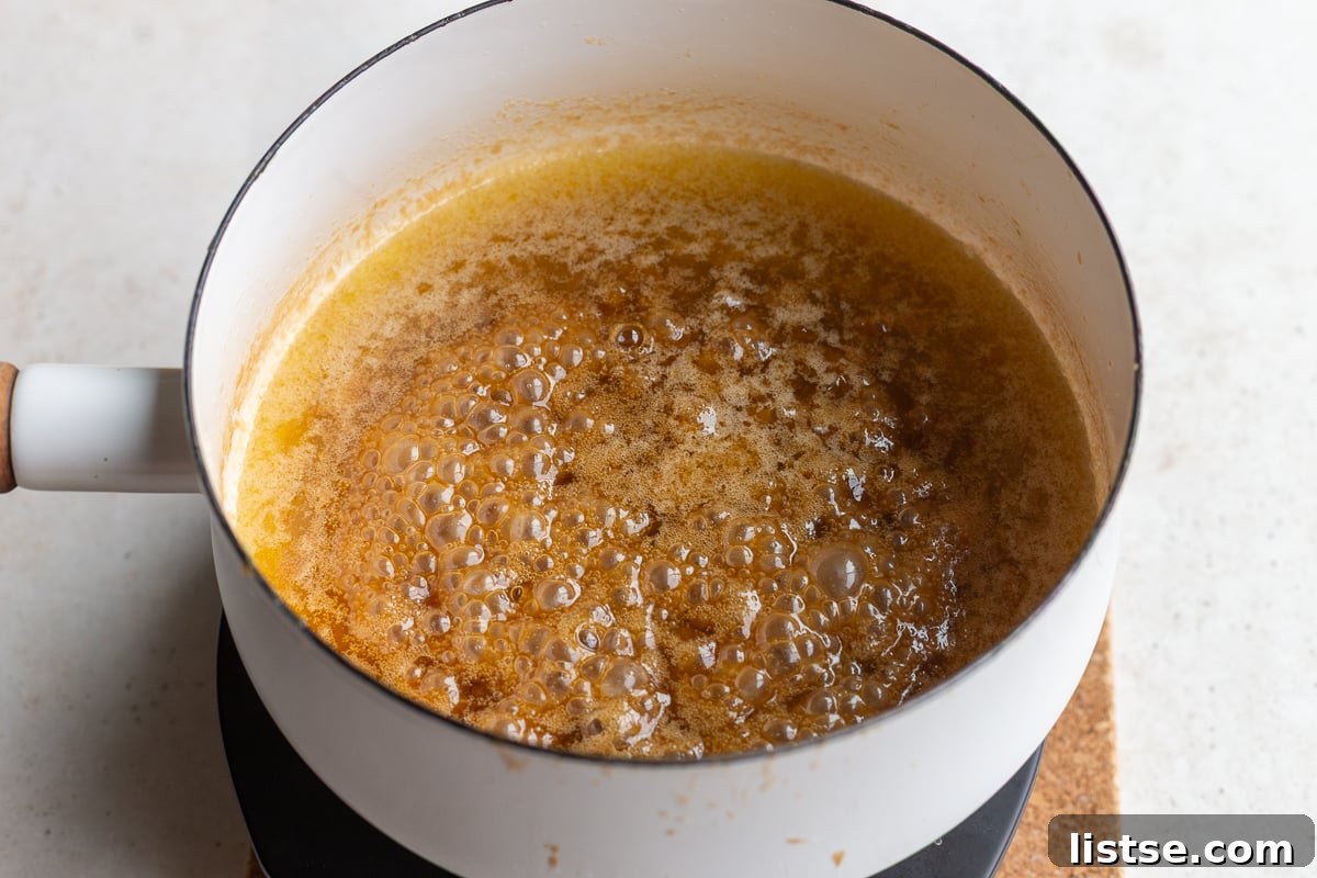 how to make christmas crack: make the toffee by simmering together the butter and brown sugar