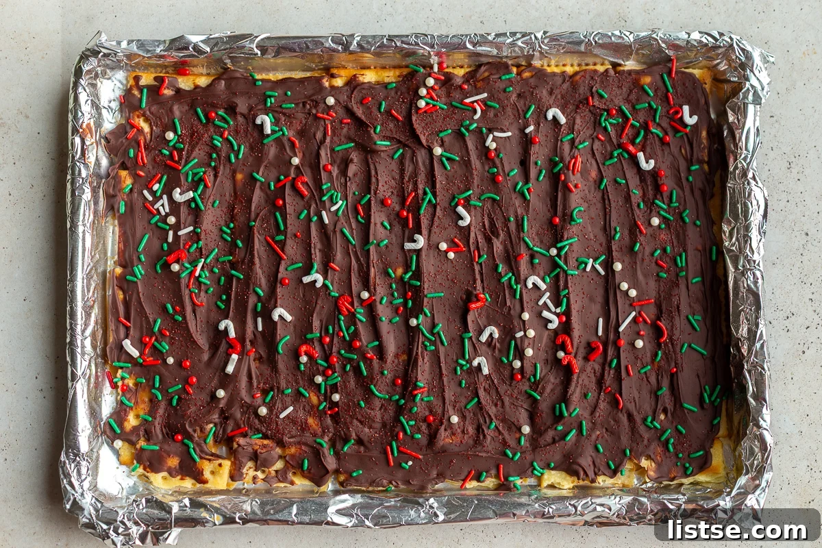 christmas crack candy on a baking tray and topped with christmas sprinkles