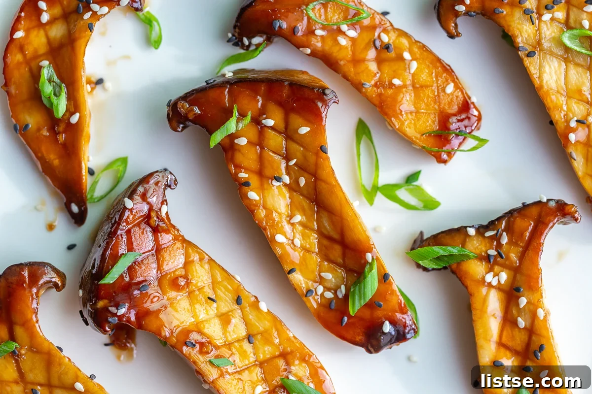 Close-up of sticky sautéed king oyster mushrooms coated in a teriyaki-style glaze, ready to serve.