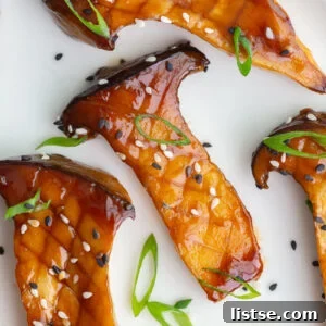 Sticky teriyaki oyster mushrooms, halved and cooked, served on a plate.