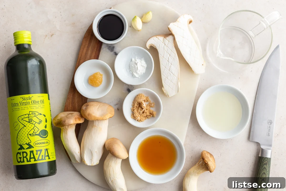 A collection of fresh ingredients laid out, including king oyster mushrooms, soy sauce, maple syrup, garlic, and ginger, ready for the recipe.