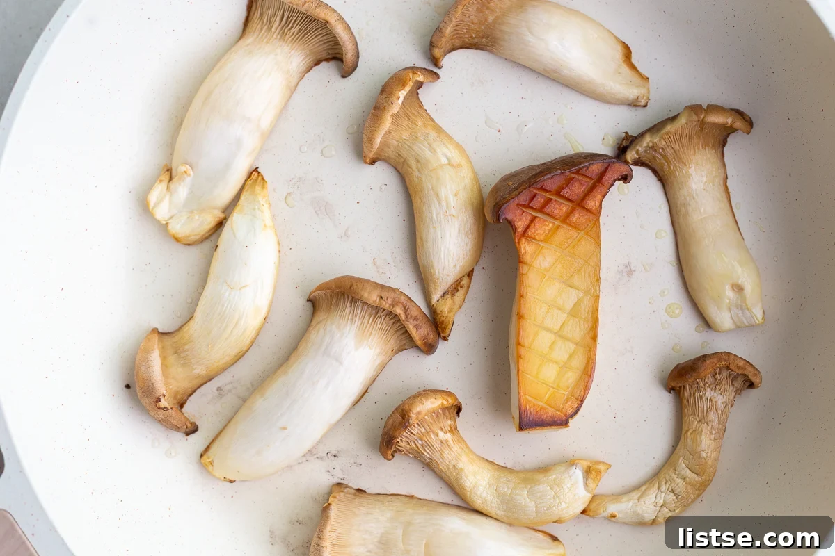 King oyster mushrooms sautéing in a hot skillet until golden brown.