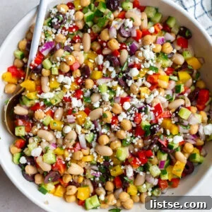 A vibrant Dense Bean Salad with chickpeas, cannellini beans, and fresh vegetables.