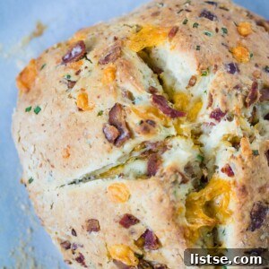 A top-down view of the golden-brown Bacon Cheddar Chive Bread loaf.