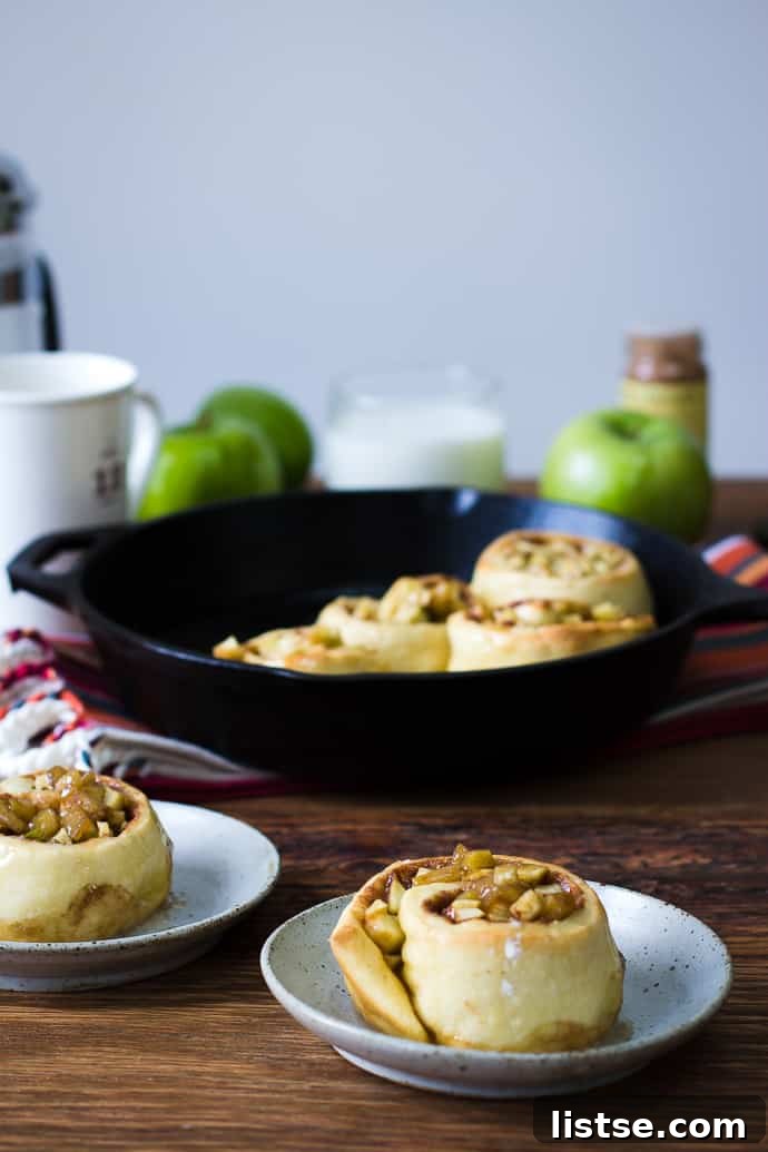Apple Cinnamon Swirls 2 Fırından yeni çıkmış elmalı tarçınlı ruloların yakın çekimi, üzerindeki elma parçacıkları ve tarçın dolgusu belirgin