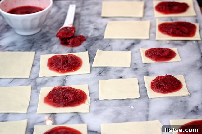 Adding strawberry filling to half of the pastry rectangles