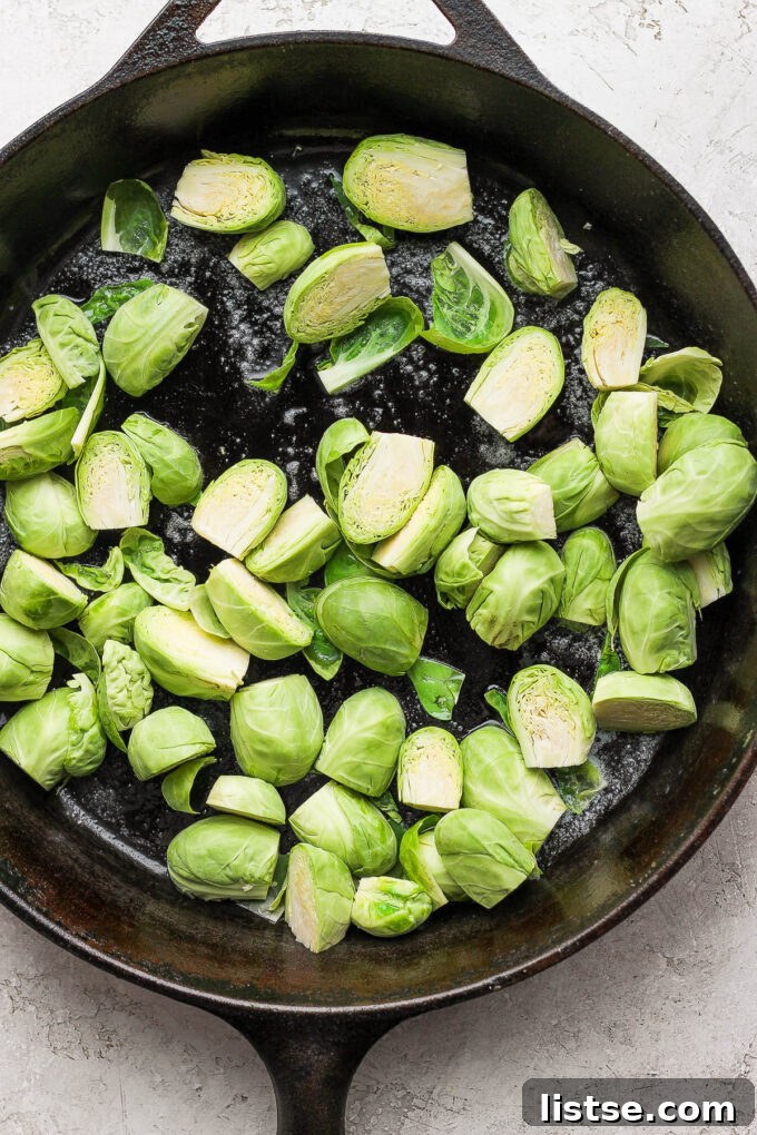 Quick and Crispy Sautéed Brussels Sprouts 6 Freshly halved Brussels sprouts being added to a preheated cast iron skillet, ready to be sautéed to perfection.