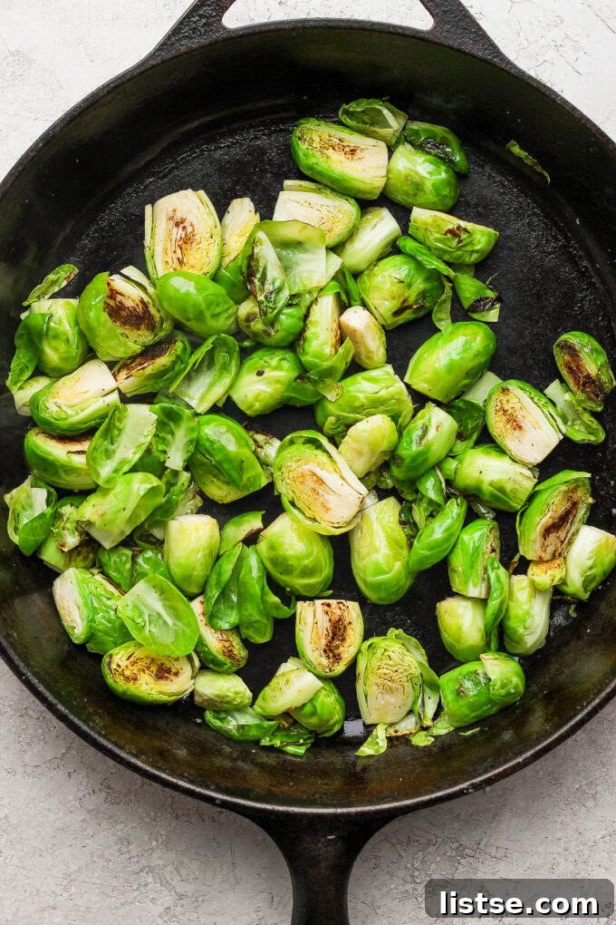 Quick and Crispy Sautéed Brussels Sprouts 7 Brussels sprouts sizzling and browning in a cast iron skillet, developing a delicious caramelized crust during the sautéing process.