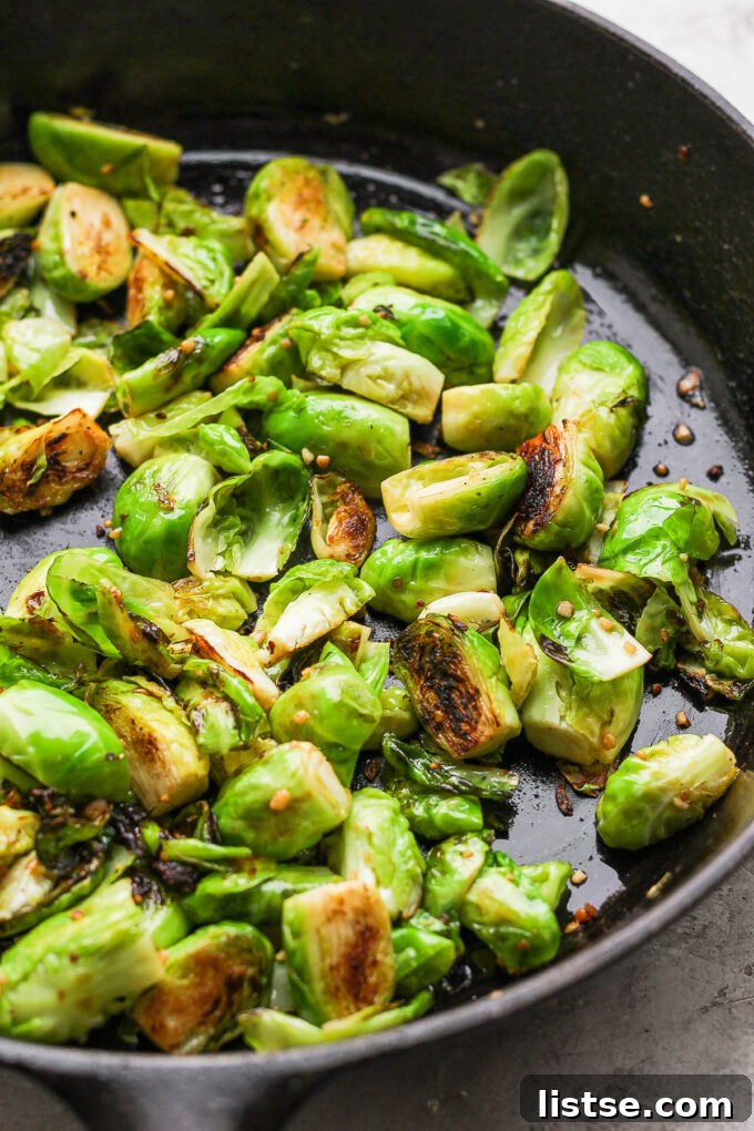 Quick and Crispy Sautéed Brussels Sprouts 8 Brussels sprouts actively cooking and browning in a large, hot skillet with oil and butter, illustrating the essential pan-frying process.