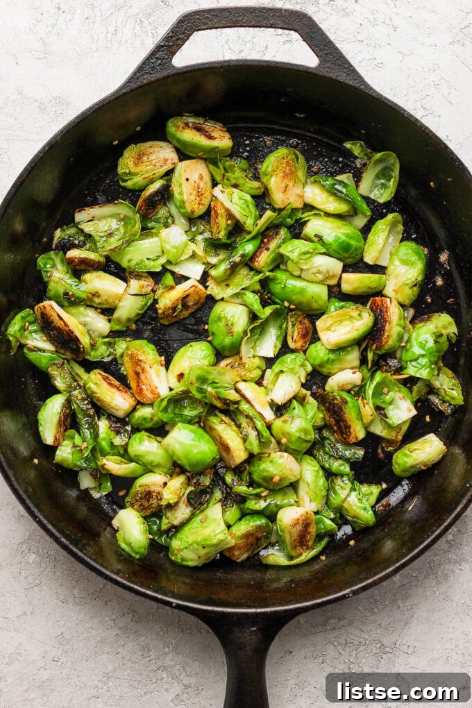 Quick and Crispy Sautéed Brussels Sprouts 9 Beautifully sautéed Brussels sprouts simmering in a cast iron skillet, ready for final seasoning or customization.