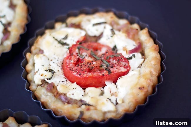 Goat Cheese and Thyme Tarts Golden brown goat cheese and tomato tart with fresh herbs on a plate