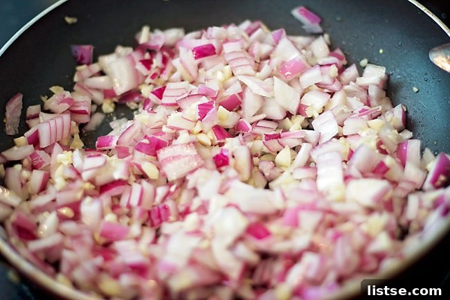 Rustic Goat Cheese and Thyme Tartlets 3 Sautéing diced red onions and garlic in a pan