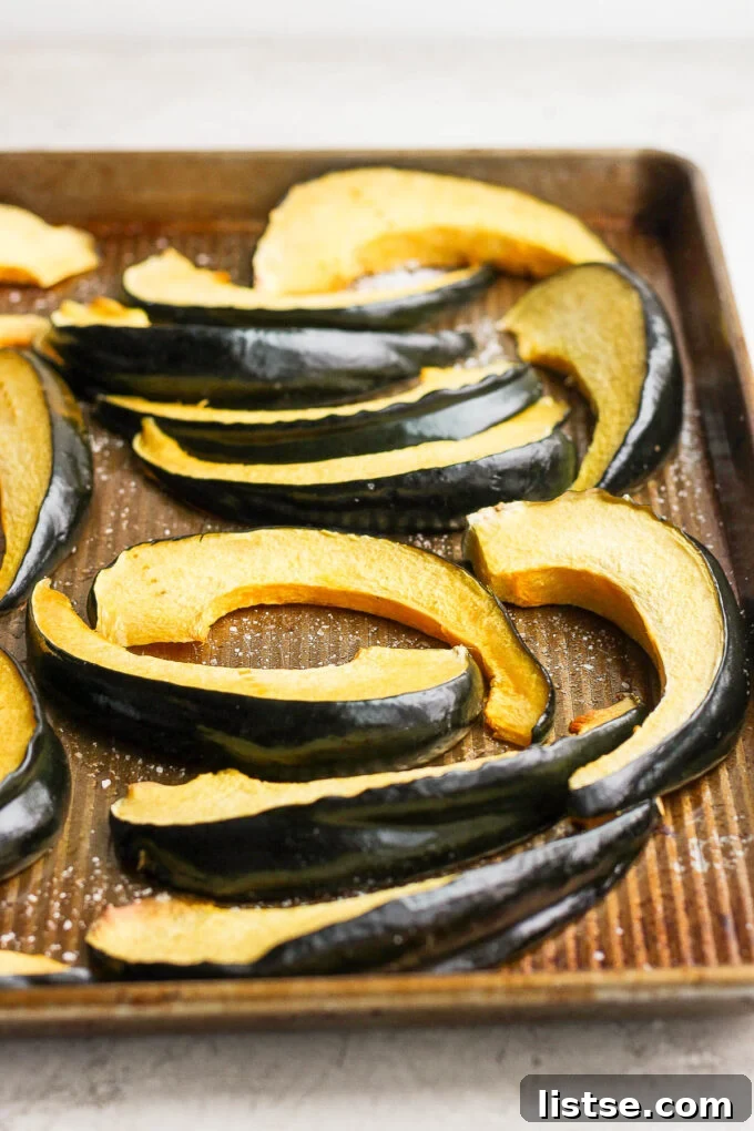 Freshly sliced acorn squash pieces arranged on a baking sheet, ready for roasting.
