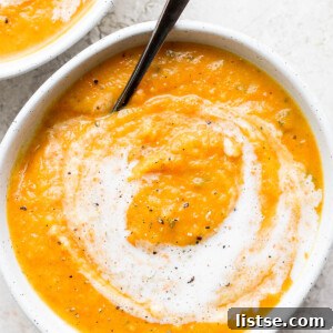 Acorn squash soup topped with a swirl of cream.