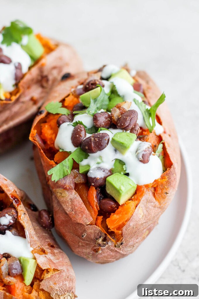 Perfectly baked sweet potatoes bursting with a seasoned black bean filling, garnished with creamy avocado and a delicate vegan crema.