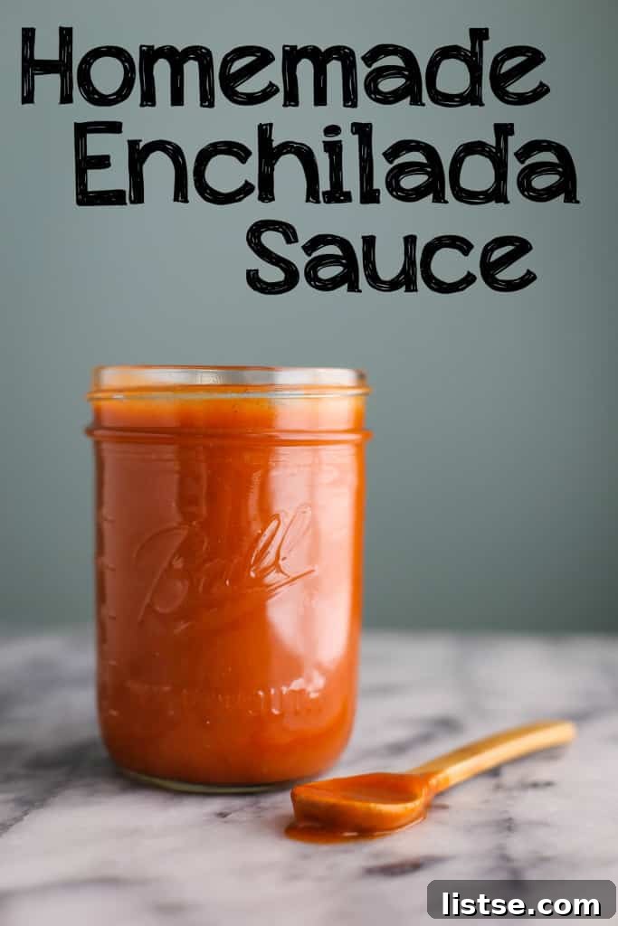 Authentic Enchilada Sauce from Scratch 6 A mason jar filled with rich homemade enchilada sauce, accompanied by a wooden spoon, set against a green backdrop. The image has a text overlay that reads 'Homemade Enchilada Sauce'.
