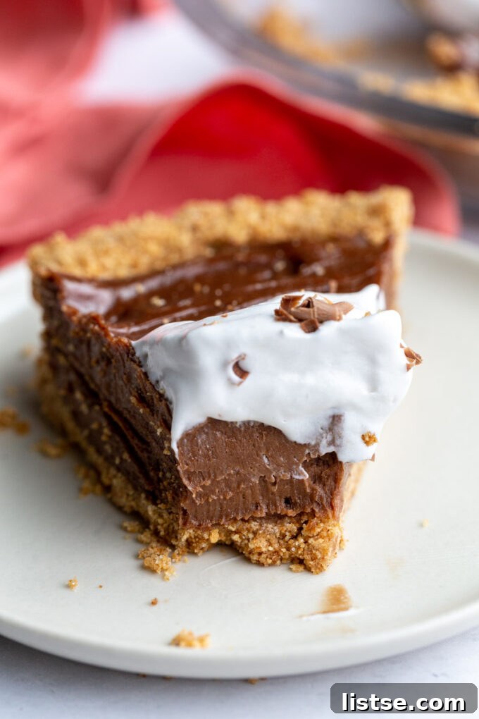Piece of vegan chocolate pie topped with whipped cream.