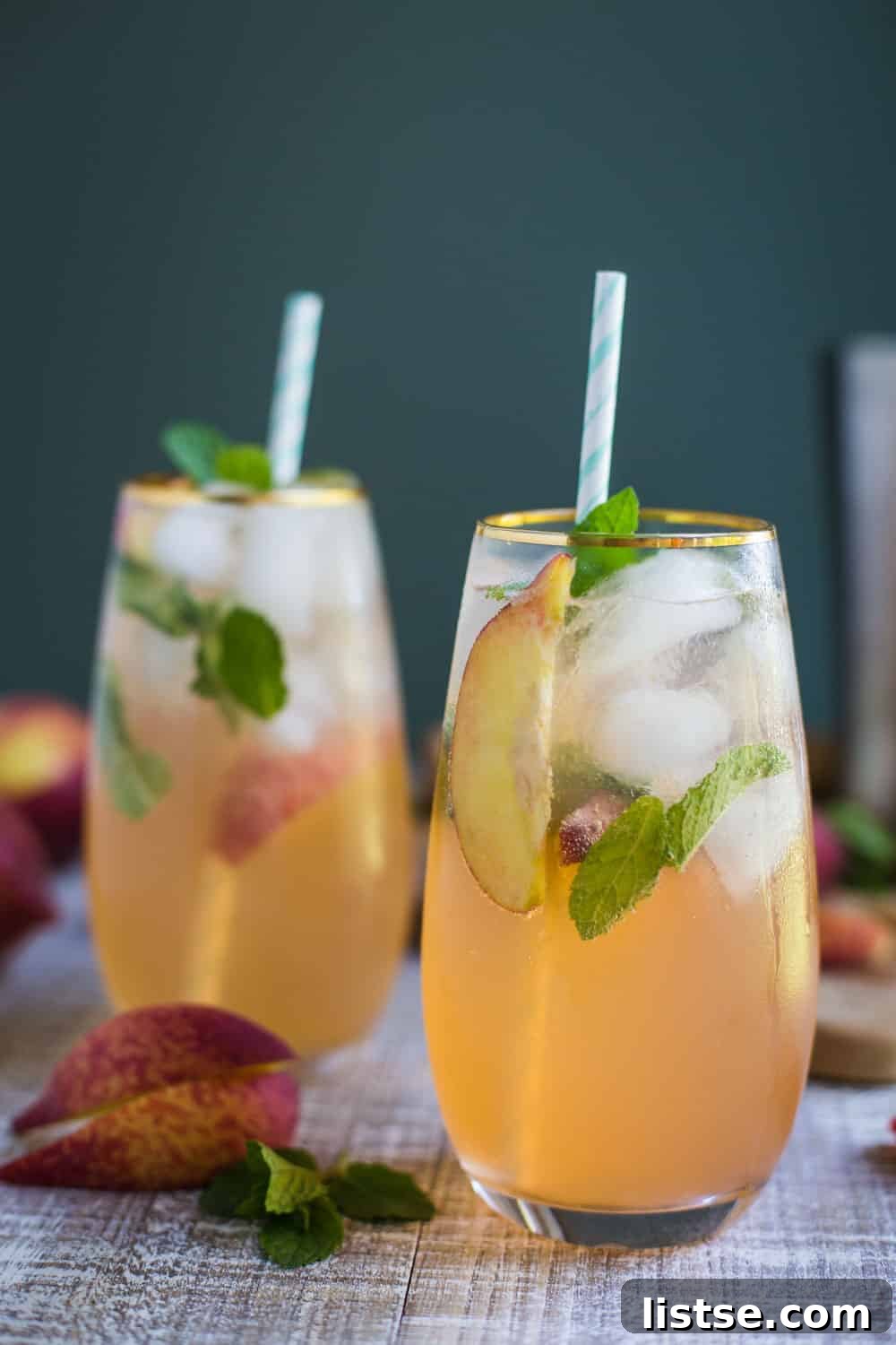 Close-up of a Peach Mojito with muddled mint and lime, showing its refreshing qualities.