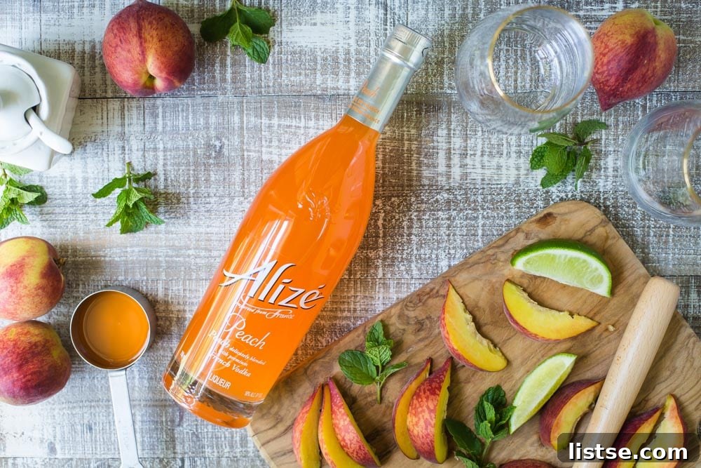 Ingredients for a Peach Mojito laid out, including Alize Peach Liqueur, mint, and lime.